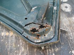 rust damage at hood hinge corner